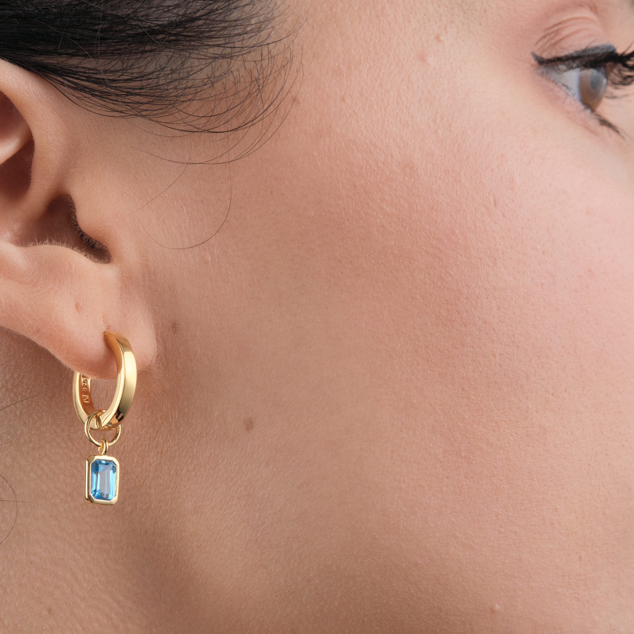 Blue Topaz Huggie Set in 18k Gold Vermeil - Beautiful Blue Topaz Earrings being worn side view.