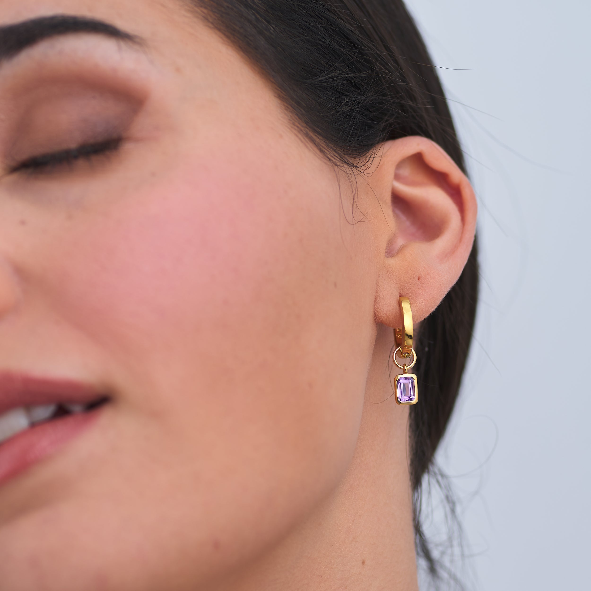 18K gold vermeil amethyst huggie hoop earrings featuring amethyst, the February birthstone, with interchangeable charms. Crafted from high-quality 18K gold vermeil for long-lasting luxury, an ideal gift for a February birthday.