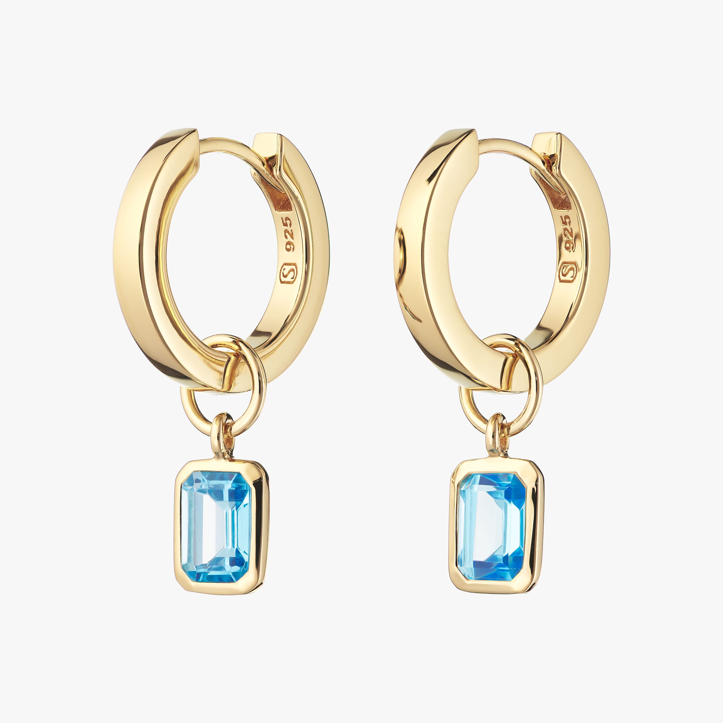 18K gold vermeil huggie hoop earrings with interchangeable blue topaz gemstone charms featuring December’s birthstone, these earrings offer a touch of elegance with the durability and affordability of high-quality gold vermeil.