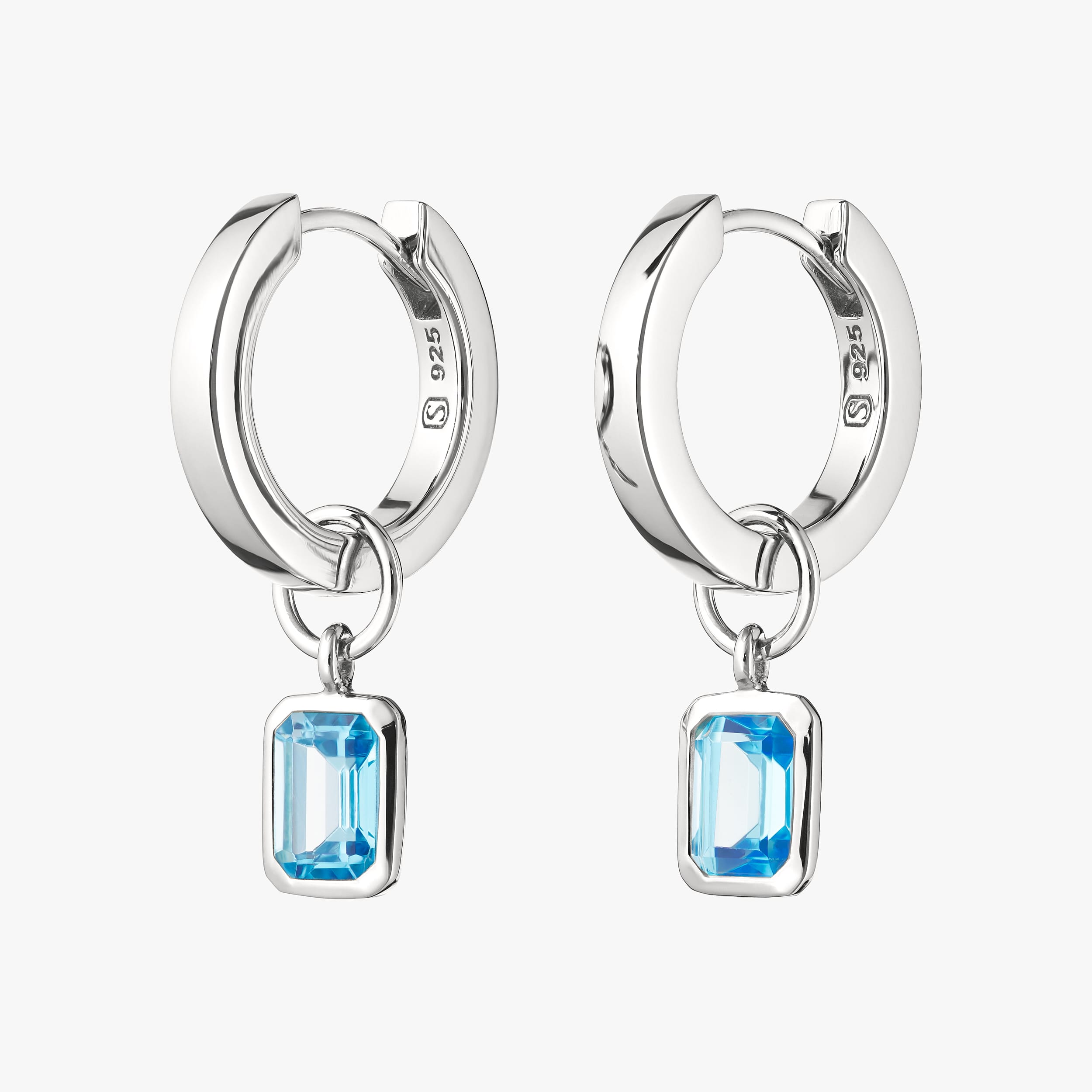 Sterling silver huggie hoop earrings with interchangeable blue topaz gemstone charms featuring a stunning blue topaz set in durable, hypoallergenic sterling silver. Ideal for personalised jewellery, offering affordable luxury with lasting durability.