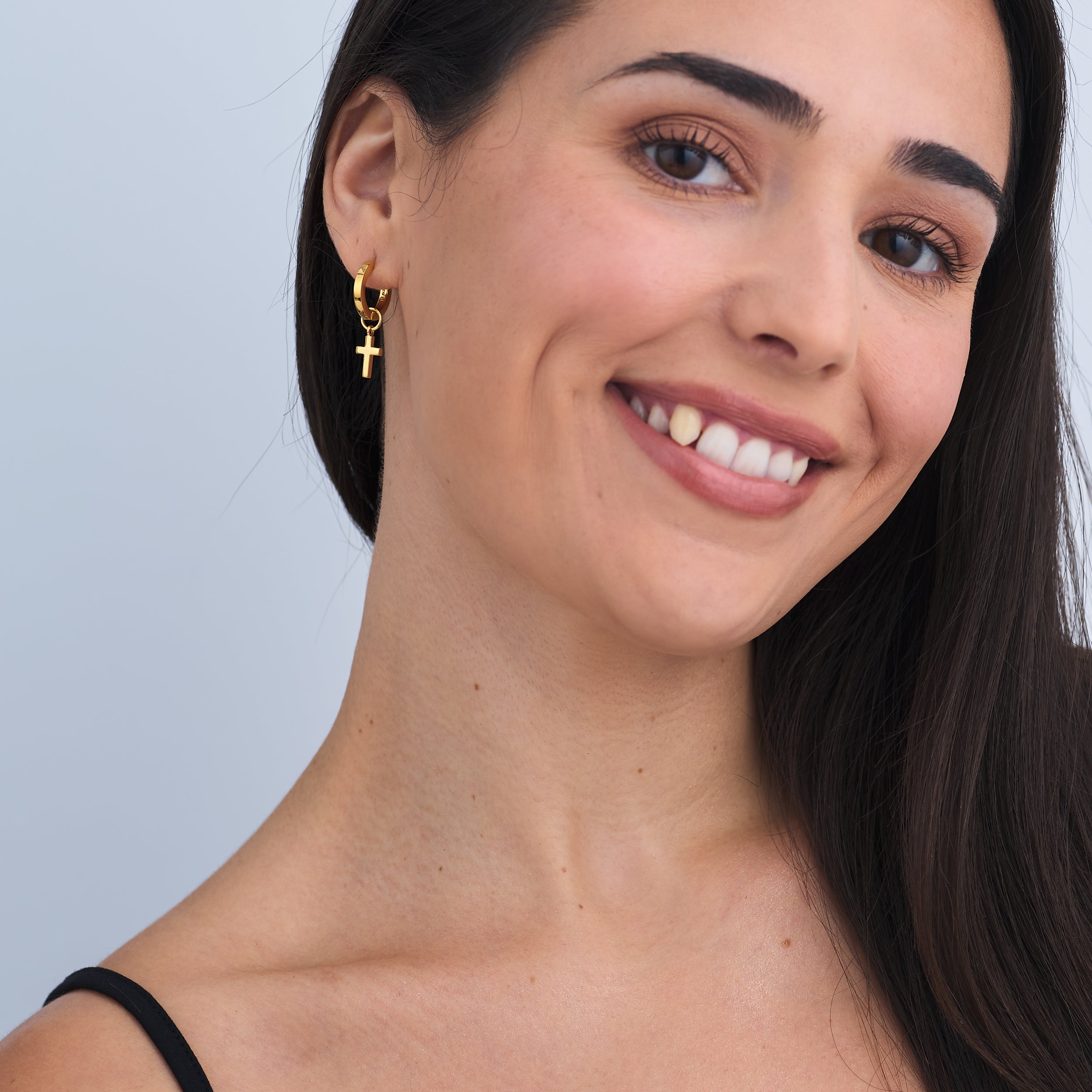 A woman wearing luxury gold vermeil in 18k with personalised cross charms, the perfect faith based gift.