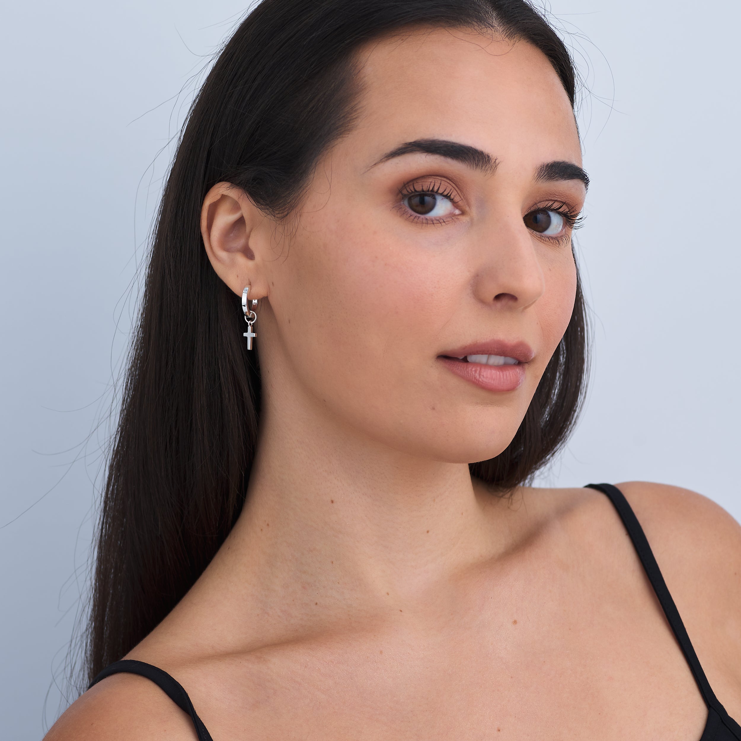 Tarnish free classic 925 sterling silver huggie hoop earrings with cross charms attached. A timeless fashion statement for faith and devotion.