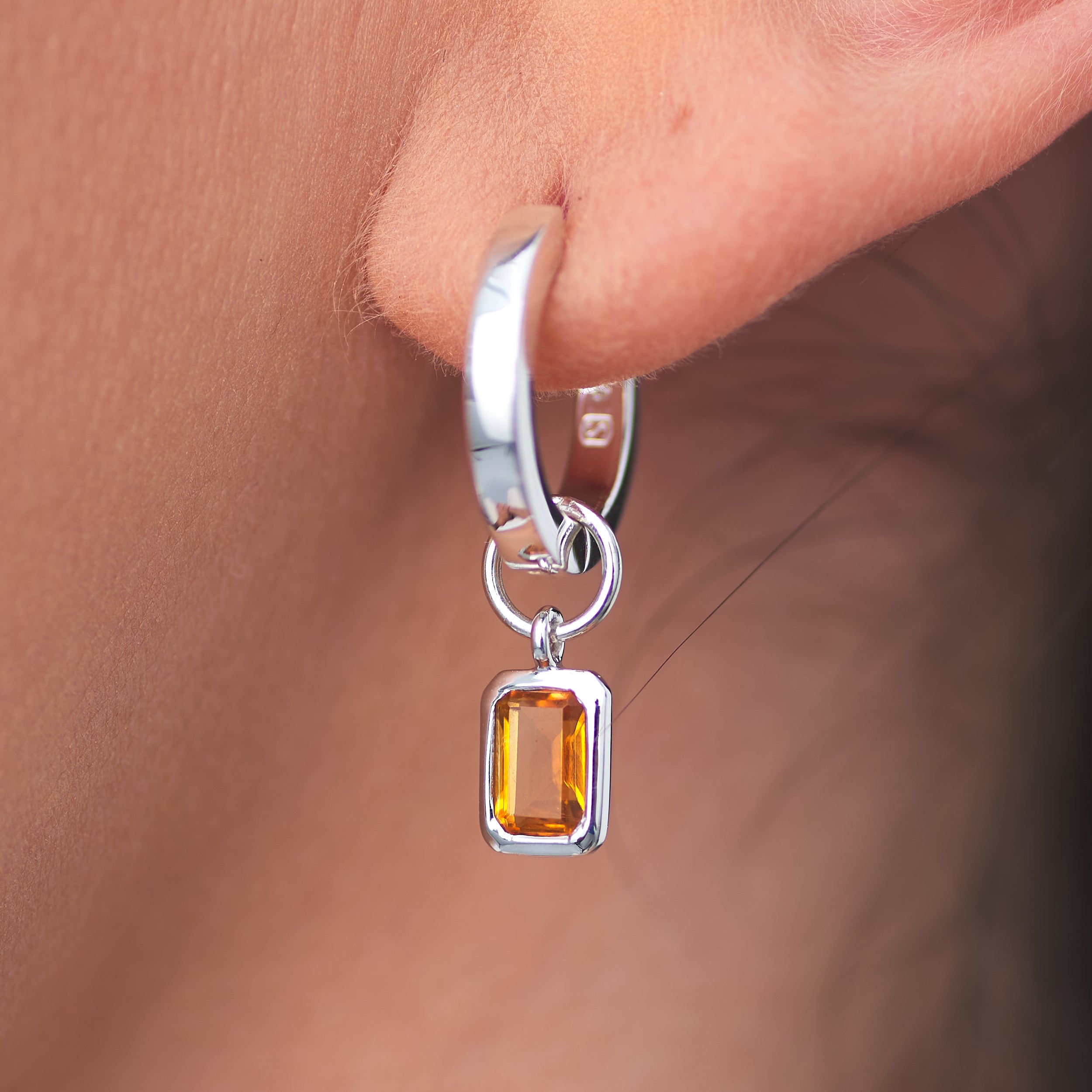 Hypoallergenic Sterling Silver Huggie Hoop earrings with detachable Golden Citrine gemstone charms that are vibrant.
