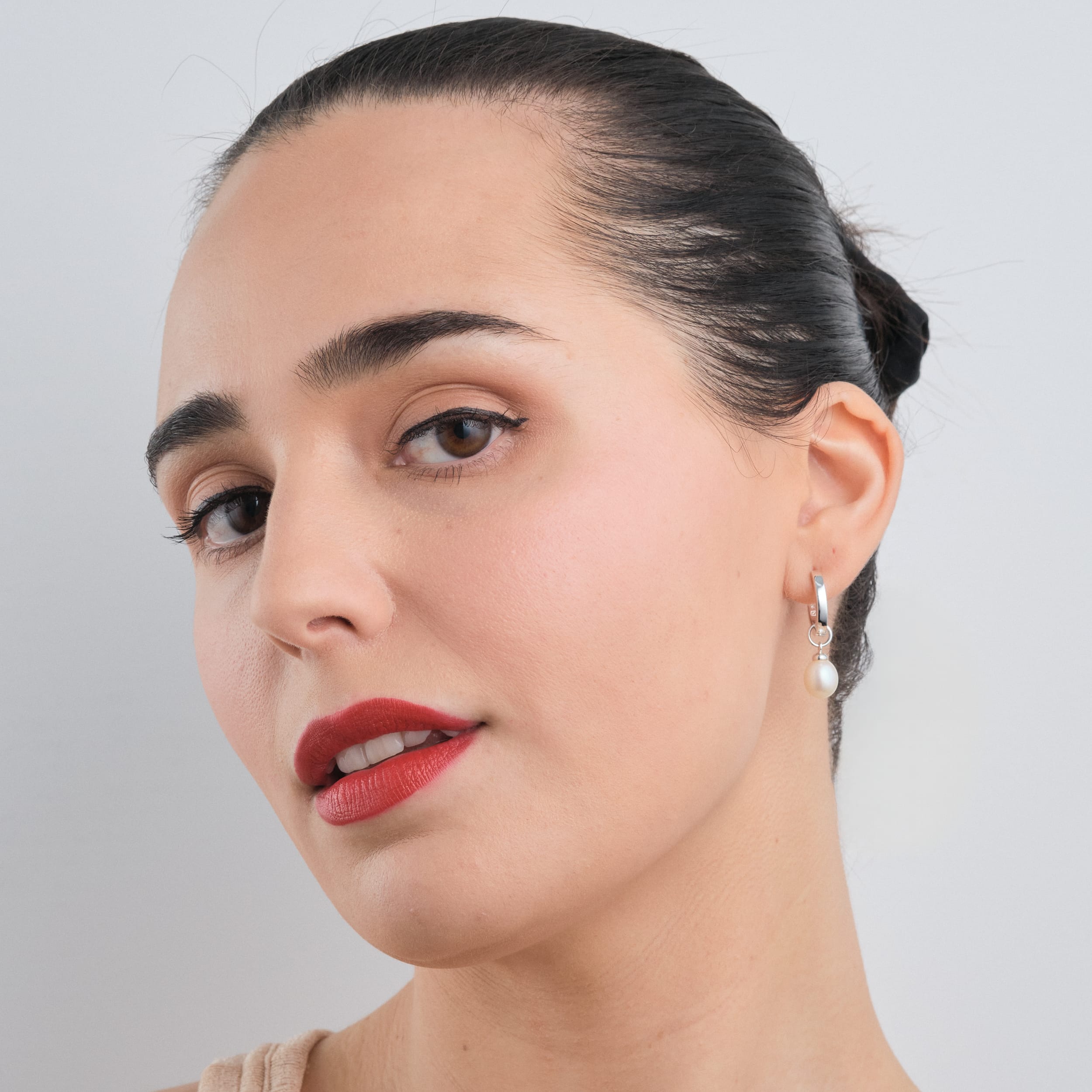 A woman wearing delicate pearl charms set in sterling silver. Ideal for weddings, anniversaries, or a refined everyday look.