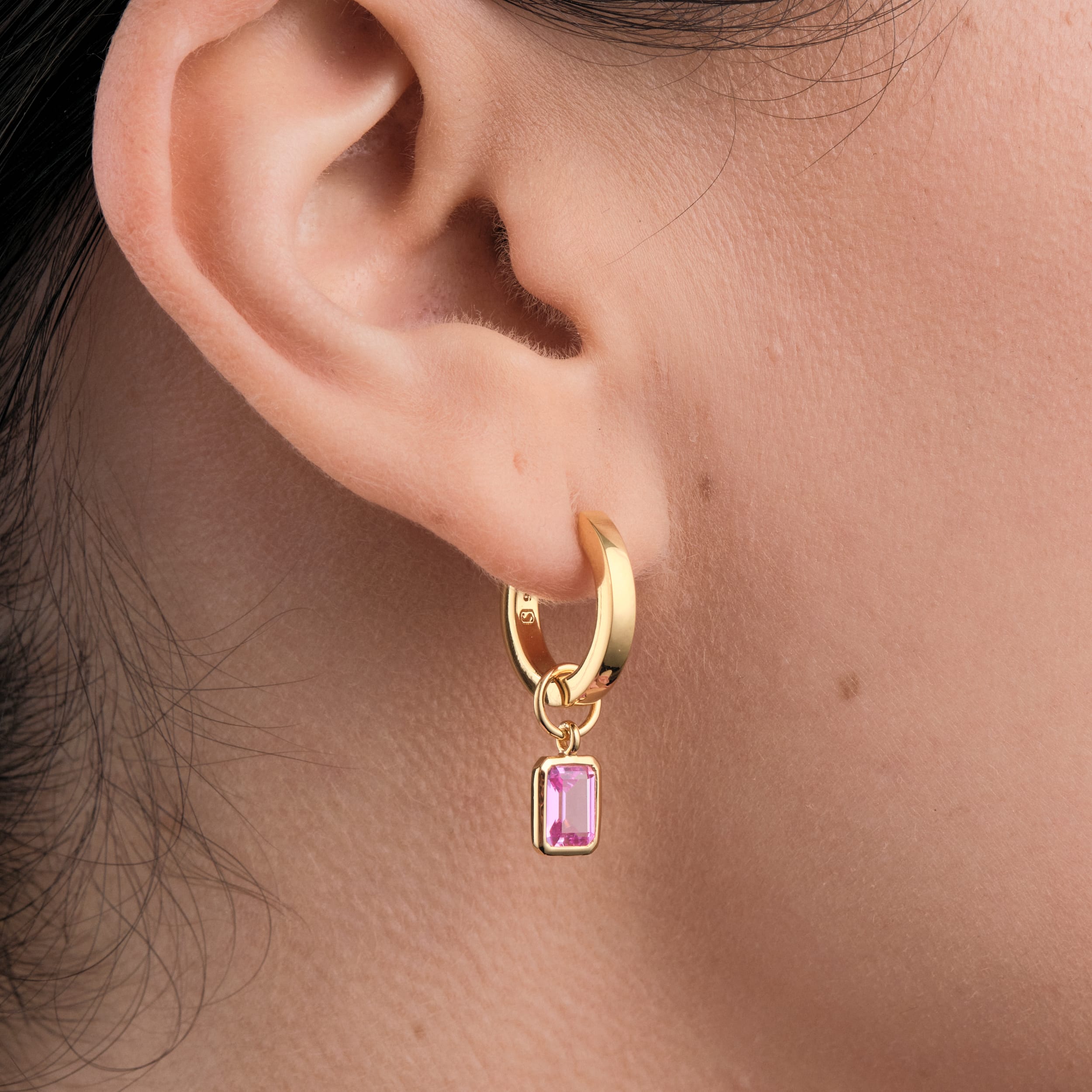 Pink Ruby Gemstone Charms in 18k Gold Vermeil being worn close up attached to affordable huggie hoop earrings perfect for everyday wear.