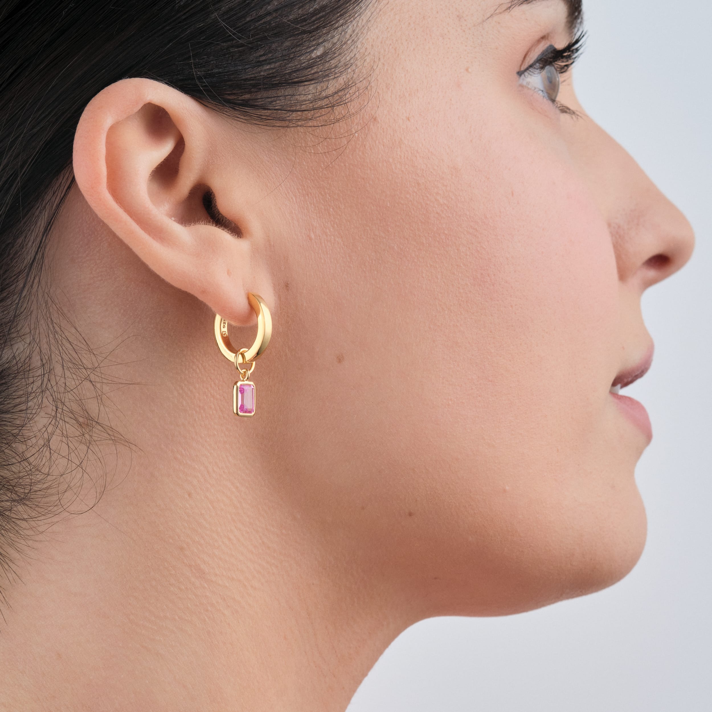 Pink Ruby Gemstone Charms in 18k Gold Vermeil being worn by a woman side view attached to the perfect huggie hoop earring designed for all day wear.
