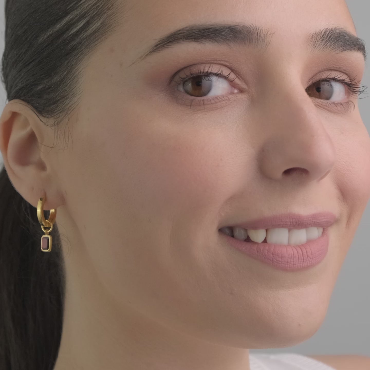 Video of a beautiful woman wearing gold vermeil in 18k with interchangeable red garnet gemstone charms. The perfect gift.