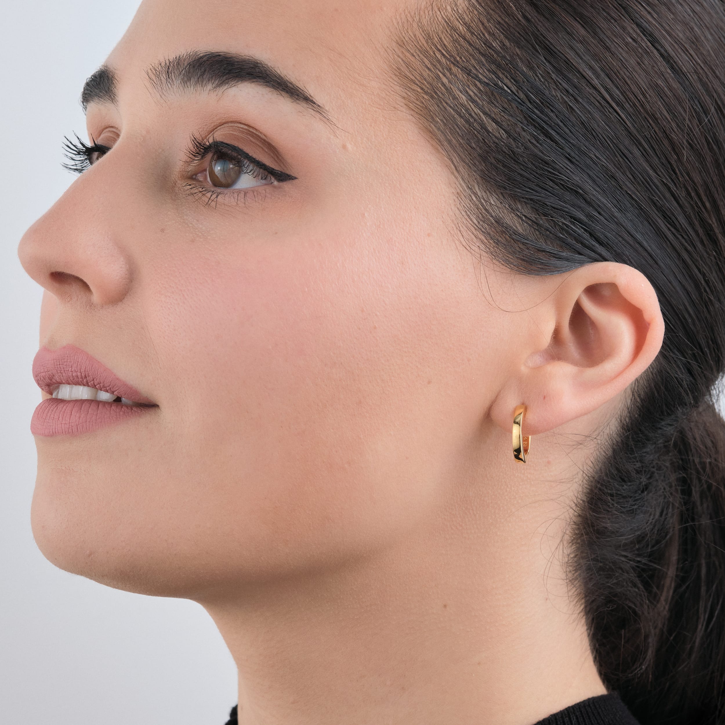 Huggie Hoops in 18k Gold Vermeil - Beautiful Gold Vermeil Earrings being worn by a woman side view.