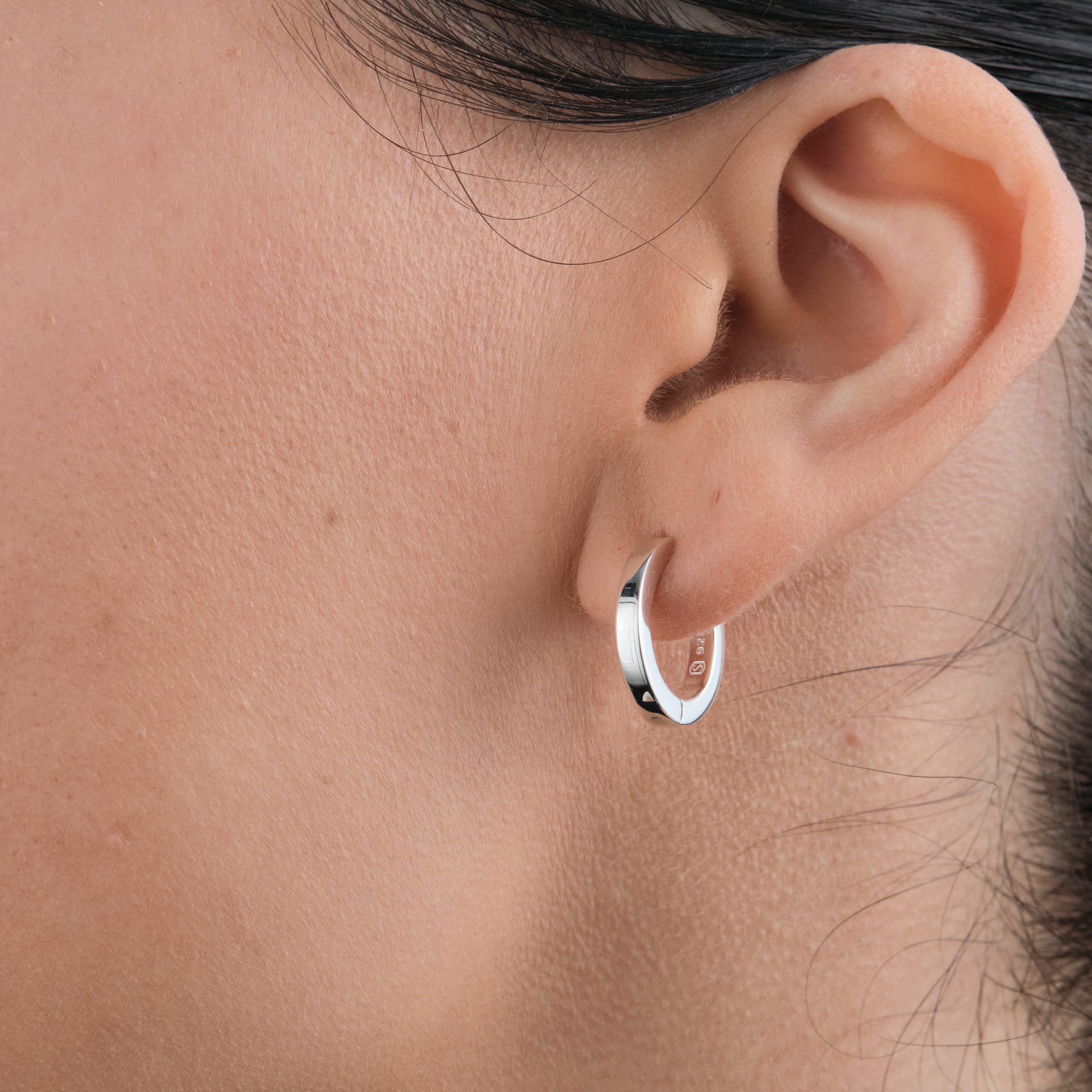 Classic sterling silver huggie hoops. A hypoallergenic, nickel-free jewellery essential, offering lasting shine and durability.