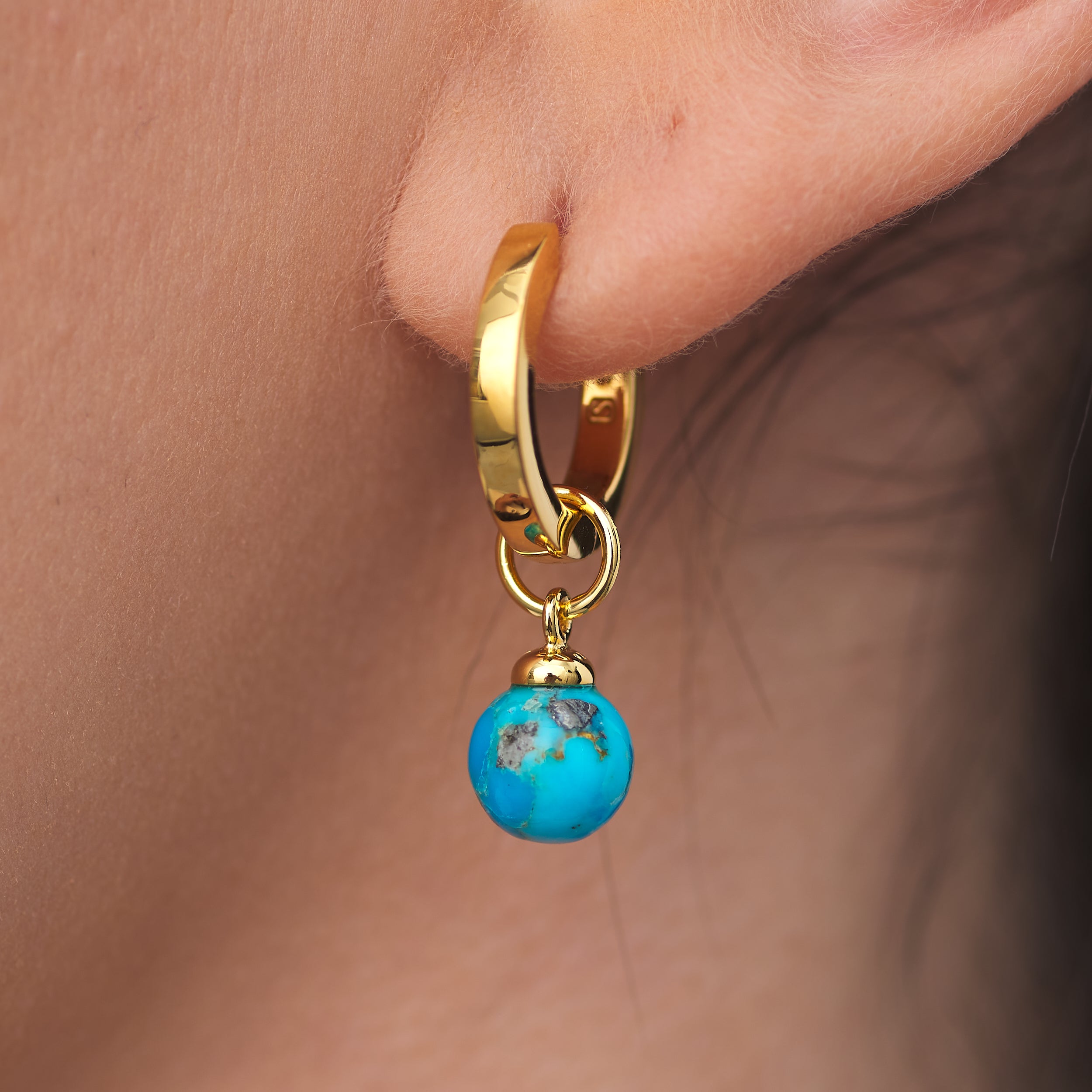 Close up of elegant 18k Gold Vermeil Huggie Hoop earrings with detachable Turquoise gemstone charm.