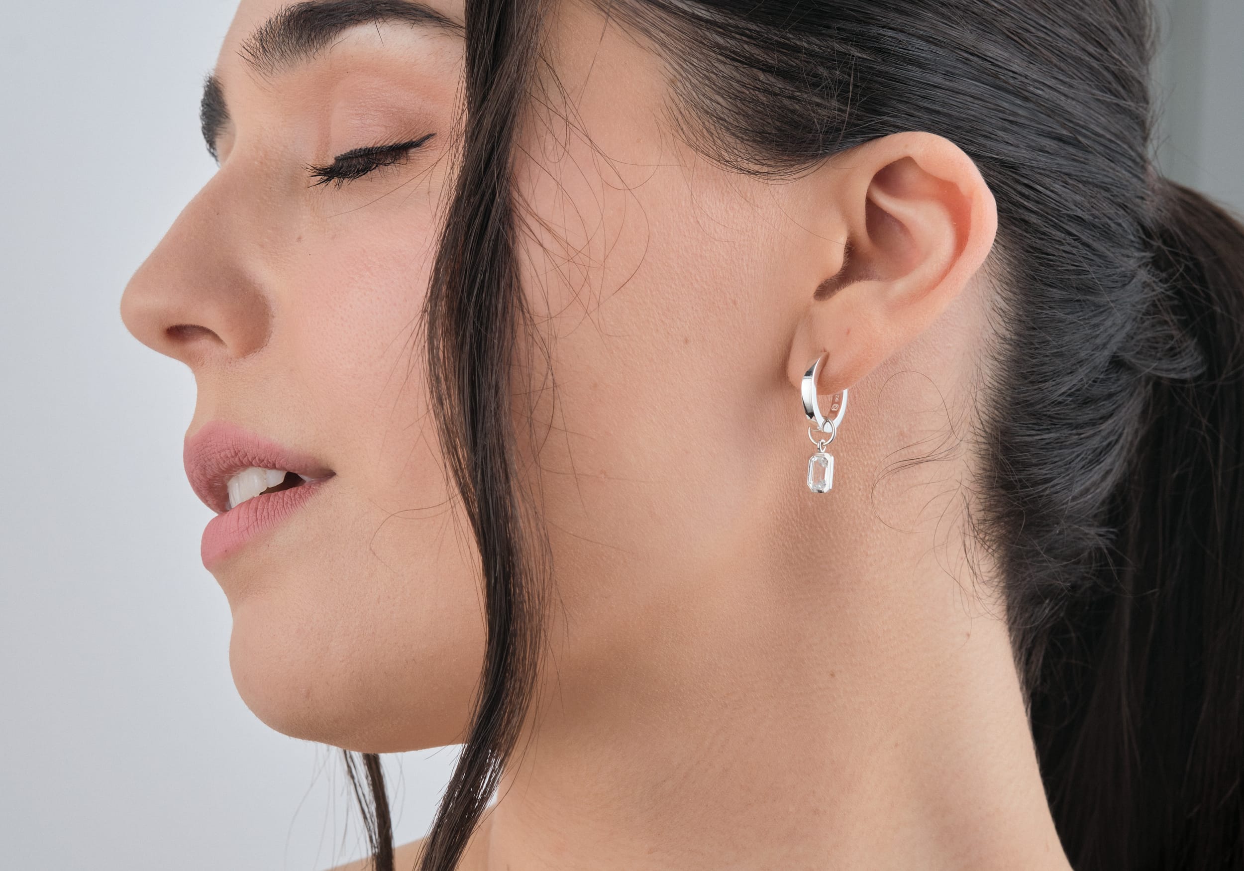 White Topaz Huggie Set in Sterling Silver - Beautiful White Topaz Earrings being worn by a woman side view